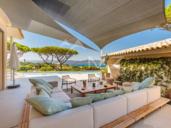 Terrasse d'une villa contemporaine à Saint-Tropez avec vue sur la mer et des arbres en arrière-plan.