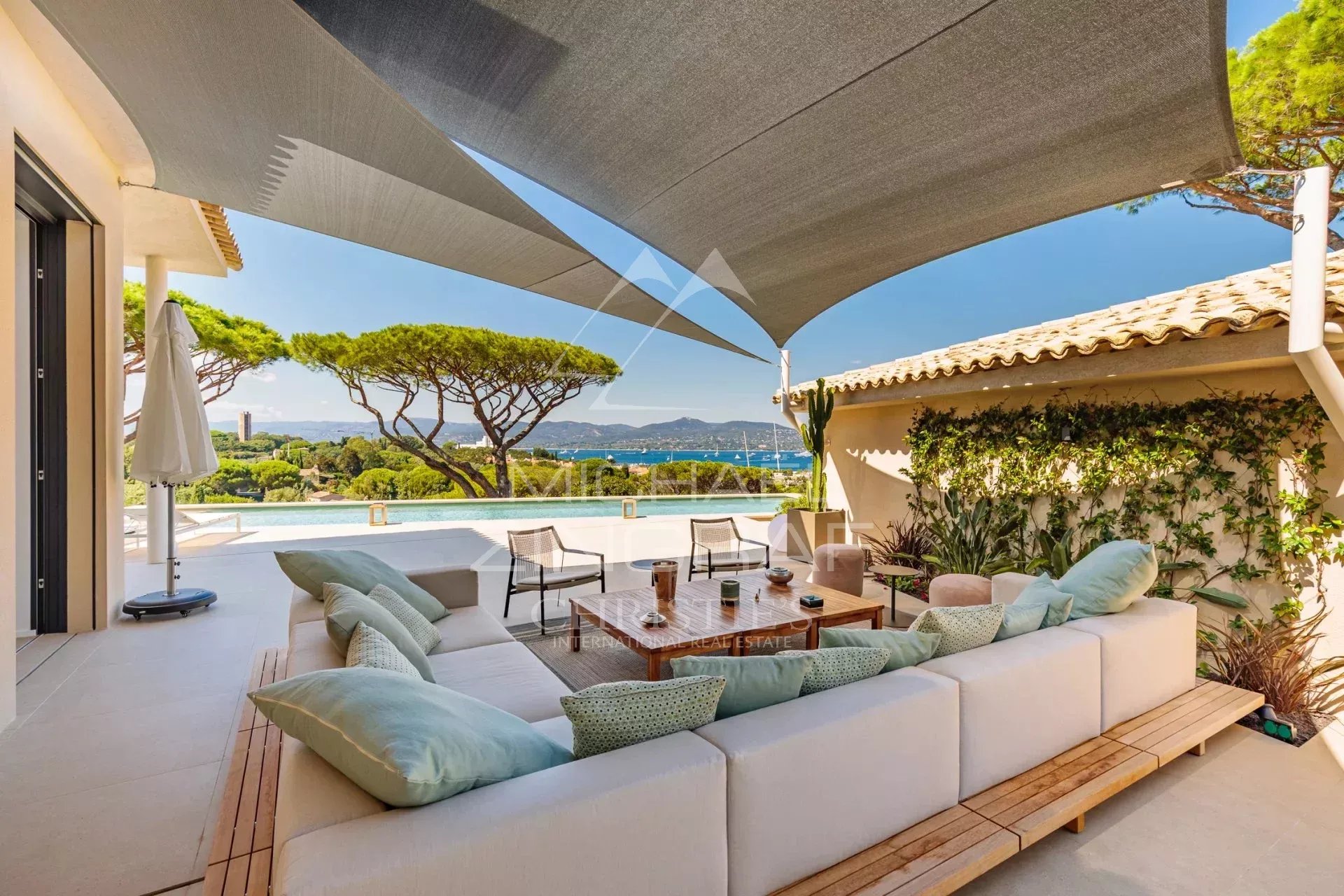 Villa contemporaine avec vue mer à Saint-Tropez Terrasse d'une villa contemporaine avec vue sur la mer à Saint-Tropez, salon extérieur élégant.