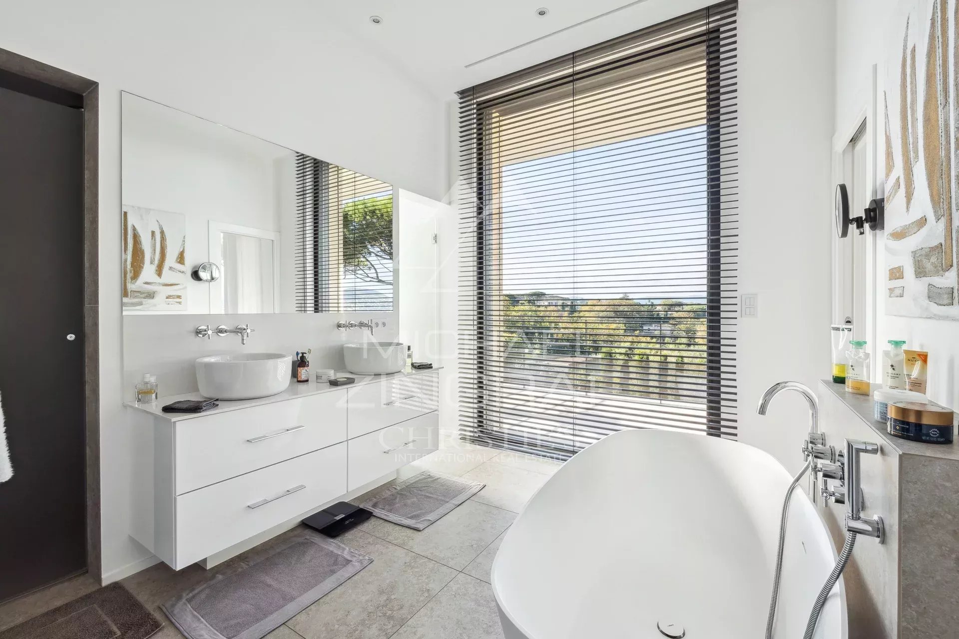 Salle de bain contemporaine à Saint-Tropez Salle de bain moderne avec baignoire, miroir et vue sur la nature à Saint-Tropez.