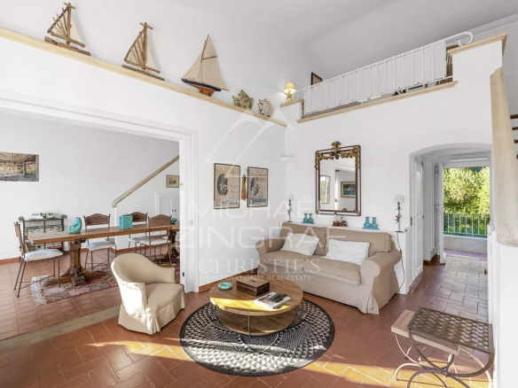 Intérieur d'un salon lumineux avec un coin repas et un escalier, dans un mazet à Ramatuelle.