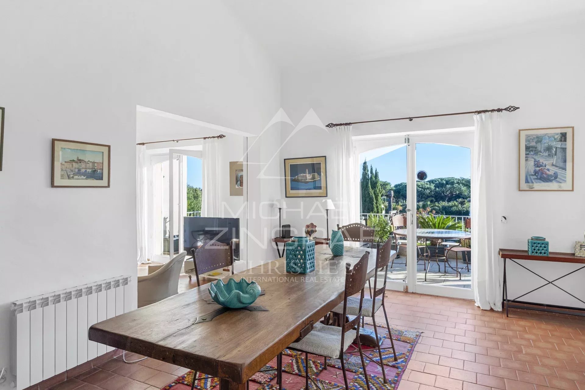 Intérieur d’un mazets à Ramatuelle Intérieur d'un mazets modulable avec une table en bois et une vue sur l'extérieur.