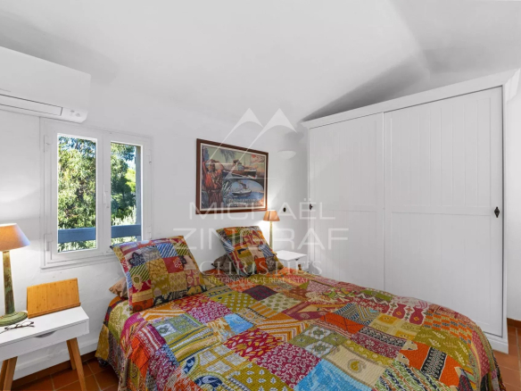 Chambre colorée avec lit double et décor artistique dans un mazet à Ramatuelle.