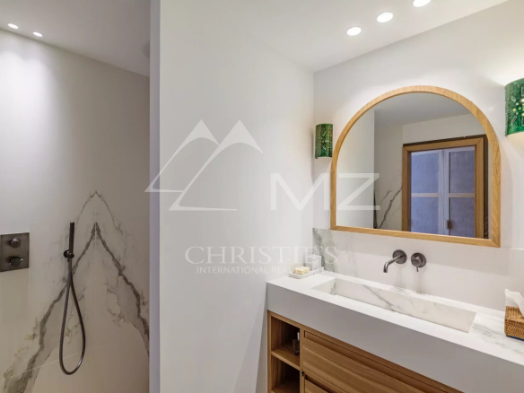 Salle de bain moderne avec douche et lavabo en marbre.