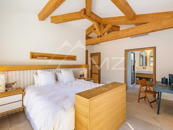 Chambre d'une villa moderne avec plafond en bois et mobilier en bois clair.
