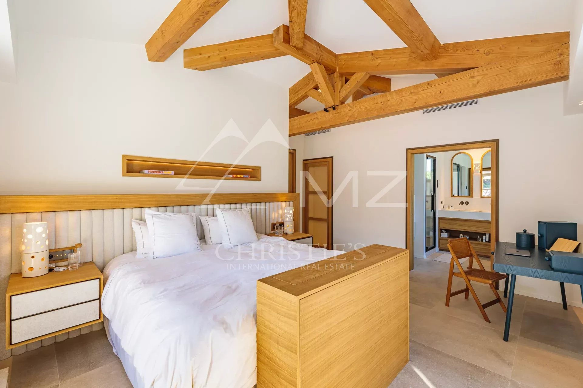 Chambre de la Villa Shesh à Ramatuelle Chambre d'une villa moderne avec plafond en bois et mobilier en bois clair.