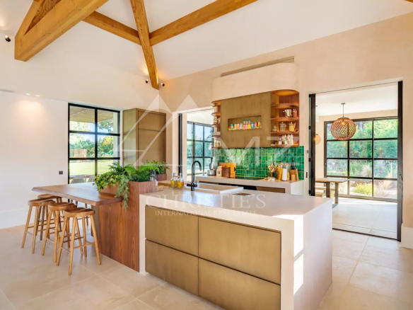 Intérieur moderne d'une villa avec cuisine ouverte et coin repas, grande luminosité.