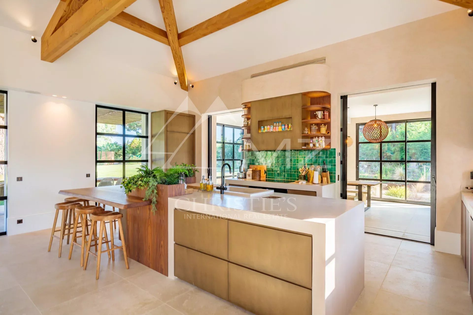 Intérieur de la Villa Shesh à Ramatuelle Intérieur moderne d'une villa avec cuisine ouverte et coin repas, grande luminosité.