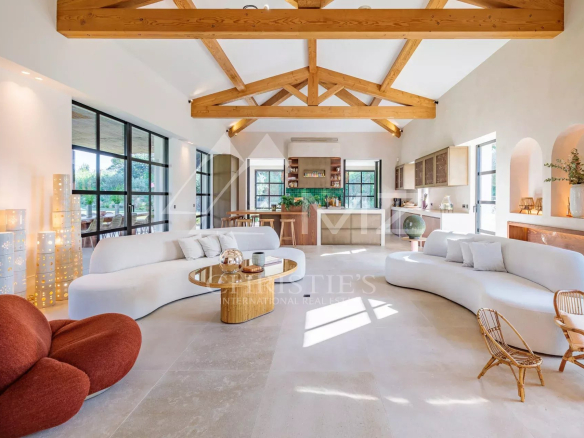 Intérieur d'une villa moderne avec un salon lumineux et une cuisine ouverte.