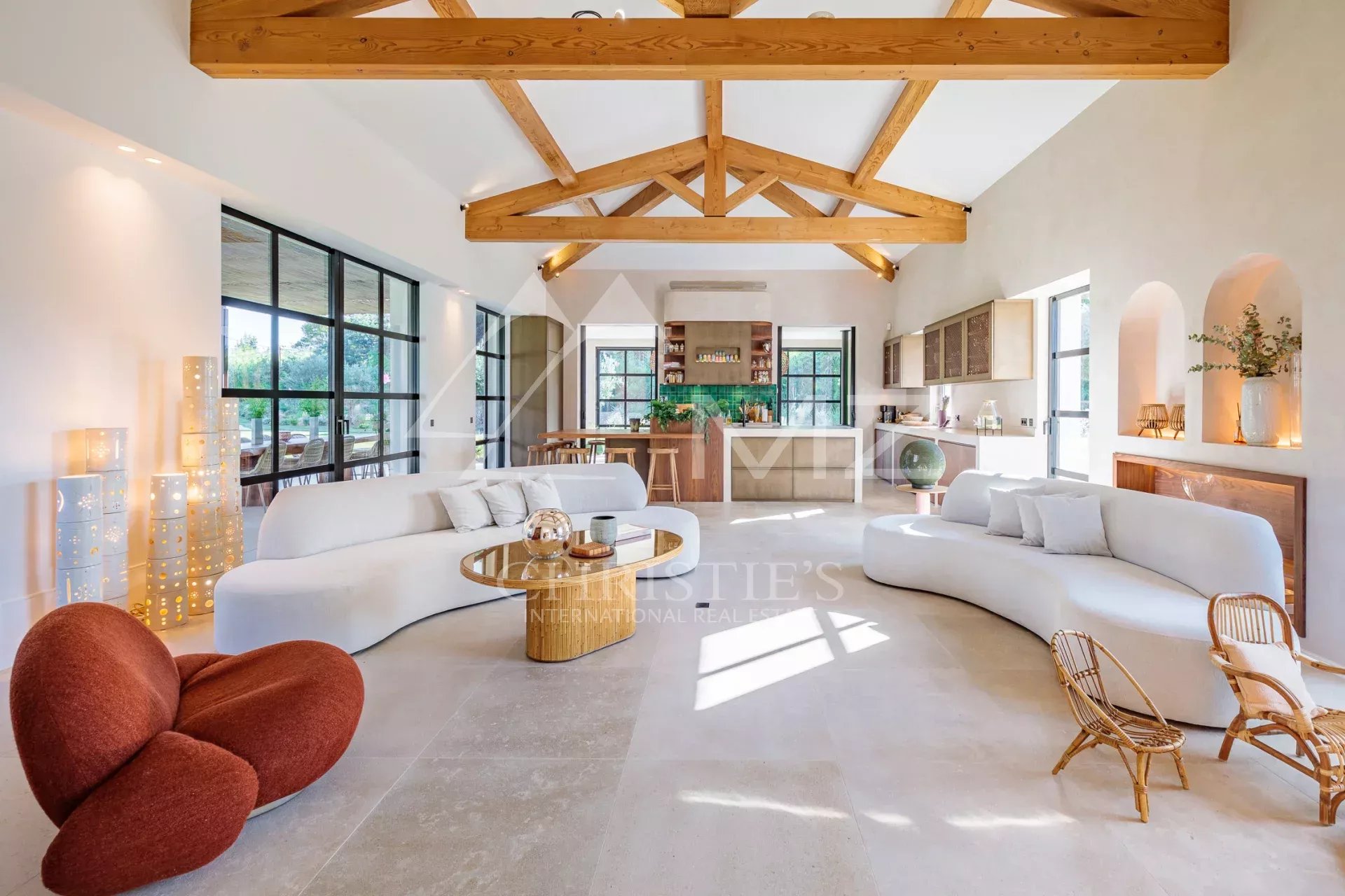 Intérieur de la Villa Shesh à Ramatuelle Intérieur d'une villa moderne avec un salon lumineux et une cuisine ouverte.