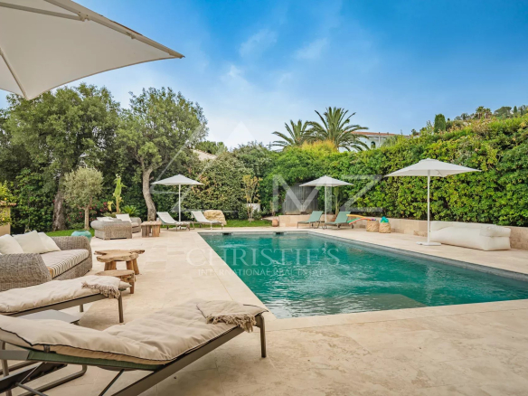 Vue de la piscine chauffée et de la terrasse d'une villa à Gassin, entourée de verdure.