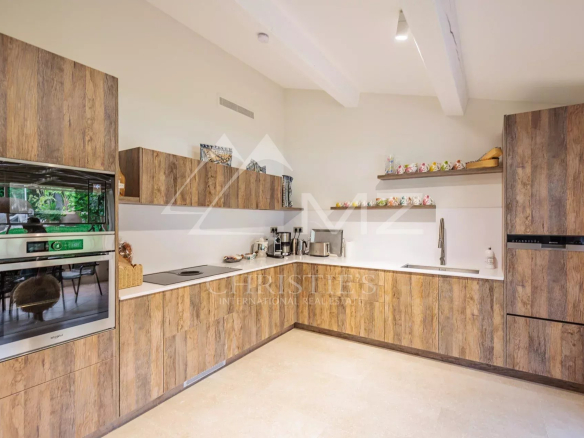 Cuisine moderne et entièrement équipée d'une villa à Gassin, avec armoires en bois et plan de travail clair.