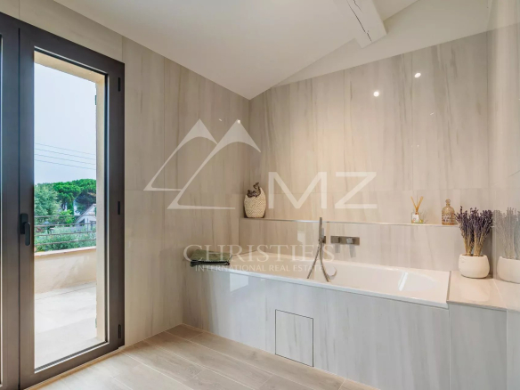 Salle de bain moderne avec baignoire et fenêtre à Gassin.