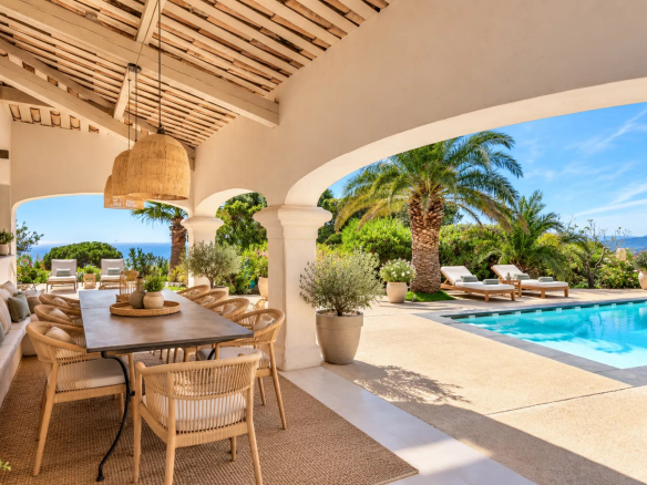 Terrasse d'une villa avec vue sur la mer, piscine et mobilier extérieur à Les Issambres.