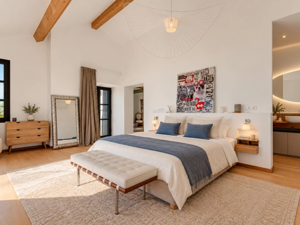 Chambre d'une villa moderne avec lit double, décoration élégante et vue sur la mer.