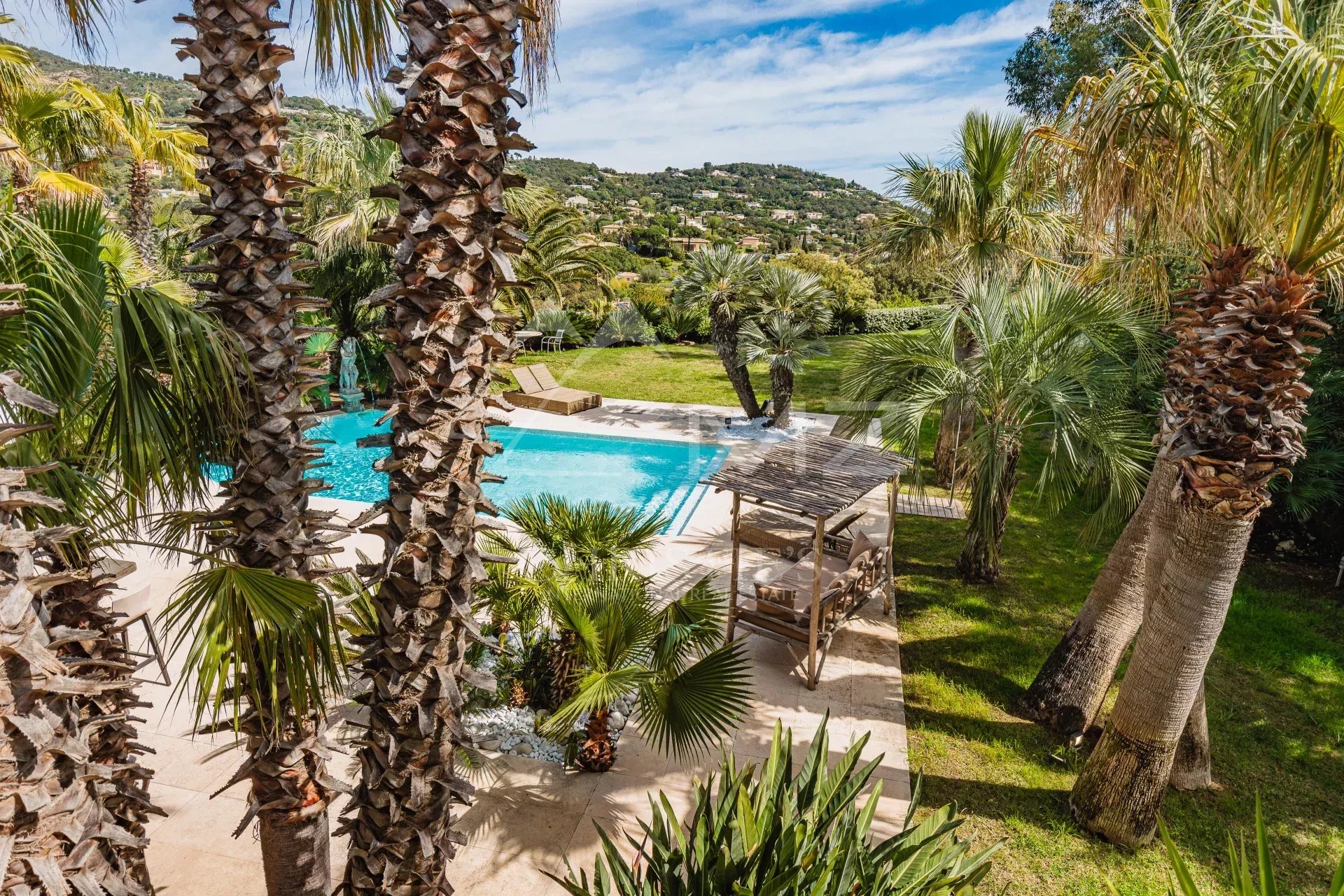 Villa avec piscine à Grimaud Vue d'une villa avec piscine entourée de palmiers à Grimaud, Golfe de Saint-Tropez.