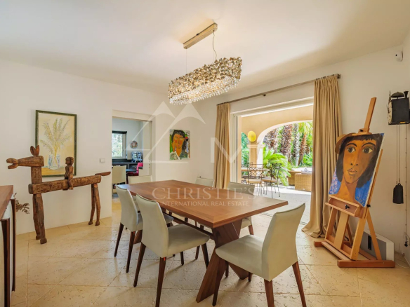 Intérieur d'une villa à Grimaud avec salle à manger et tableau artistique.