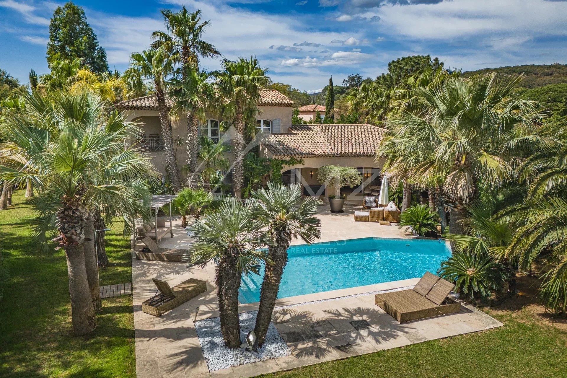Propriété familiale à Grimaud Villa avec piscine entourée de palmiers à Grimaud, Golfe de Saint-Tropez.