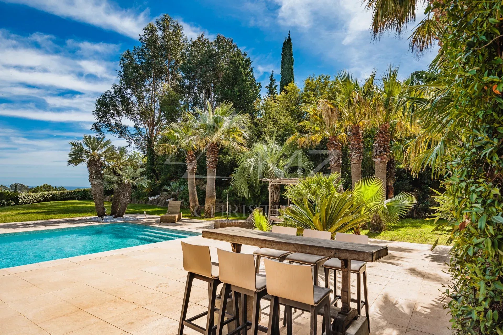 Villa de standing à Grimaud Terrasse avec piscine et palmier dans une villa à Grimaud, Golfe de Saint-Tropez.