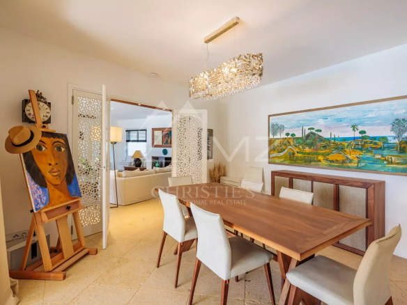 Salle à manger d'une villa à Grimaud avec table en bois et décoration artistique.