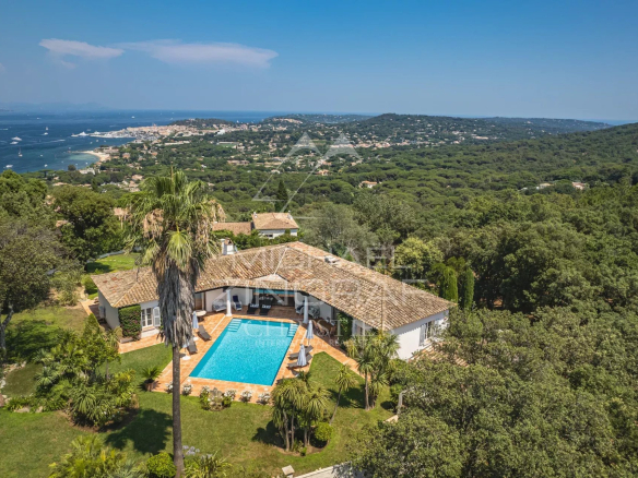 Panoramic view of the sea and the villa with swimming pool in a landscaped garden in Gassin.