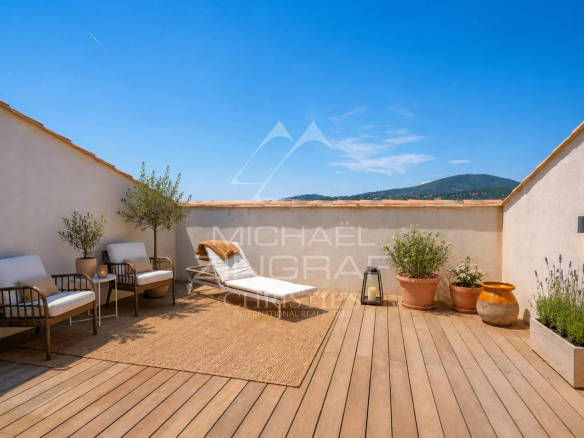 Terrace with chairs and plants in Sainte-Maxime under a blue sky.