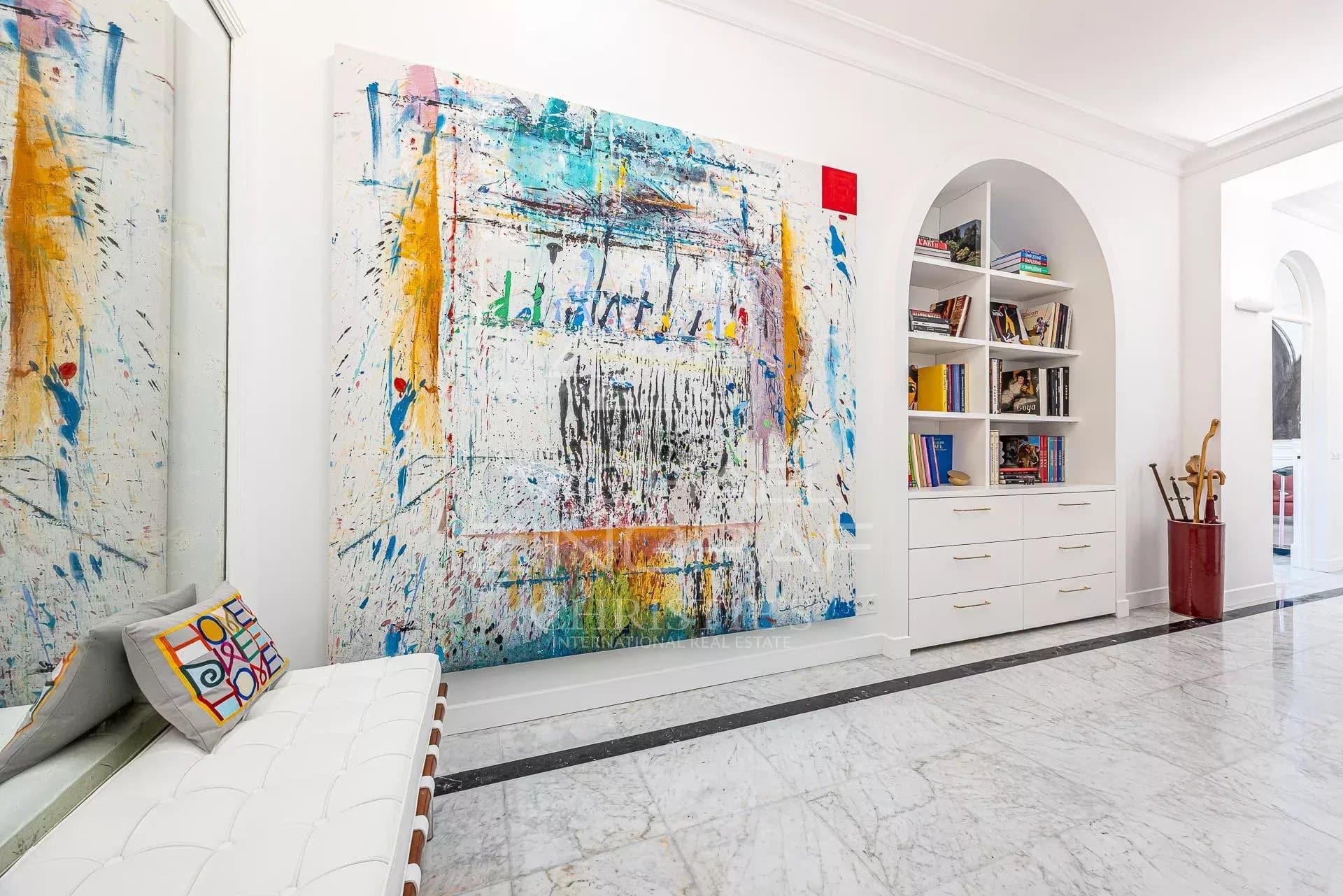 Interior of a Belle Époque apartment in Menton Interior of a stylish apartment with a large, colorful painting and modern furniture.