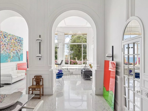 Interior of an elegant apartment with arches, colorful artwork and sea view in Menton.