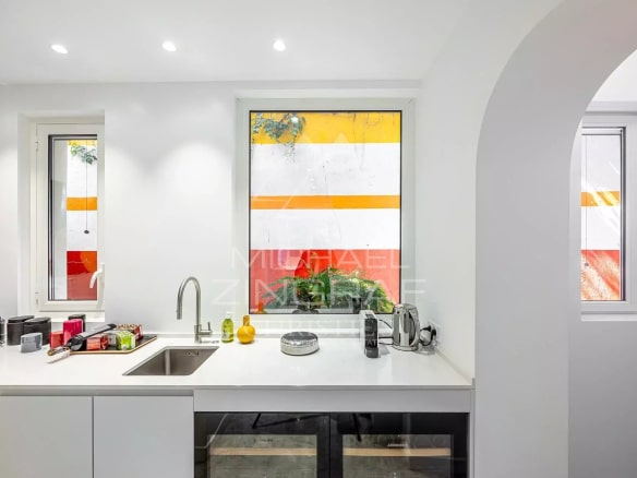 Modern kitchen with windows overlooking colorful walls.