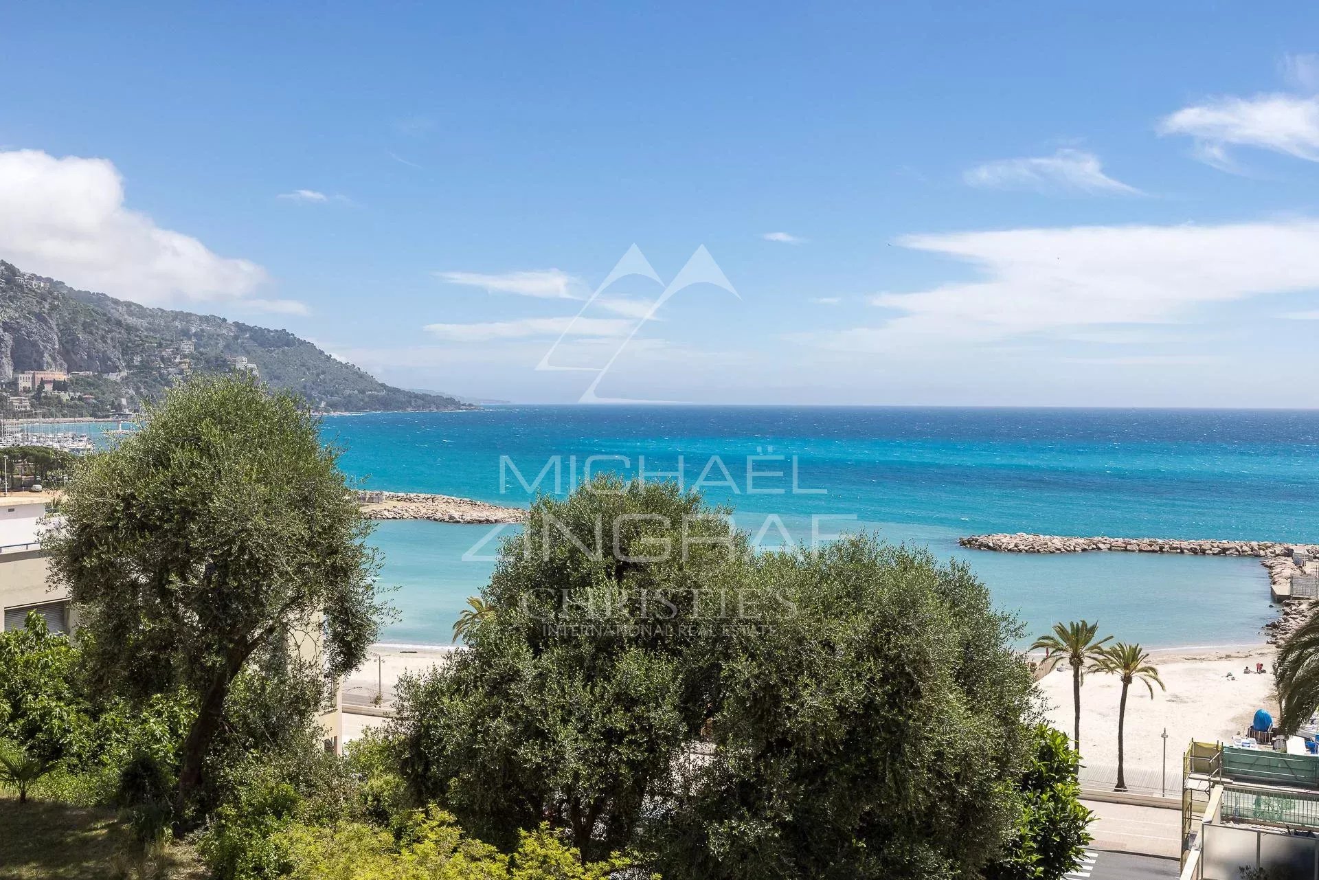Sea view from an apartment in Menton Sea view from an apartment in Menton, with trees and a beach in the background.