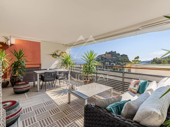 Terrasse d'un appartement à Èze avec vue sur les collines et le château.