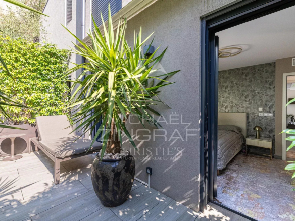 Terrasse d'un appartement à Èze avec des plantes et un mobilier moderne.