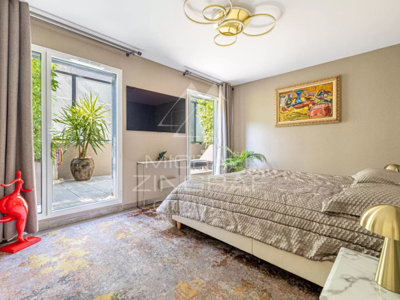 Chambre d'un appartement moderne avec lit, décoration contemporaine et accès à une terrasse.