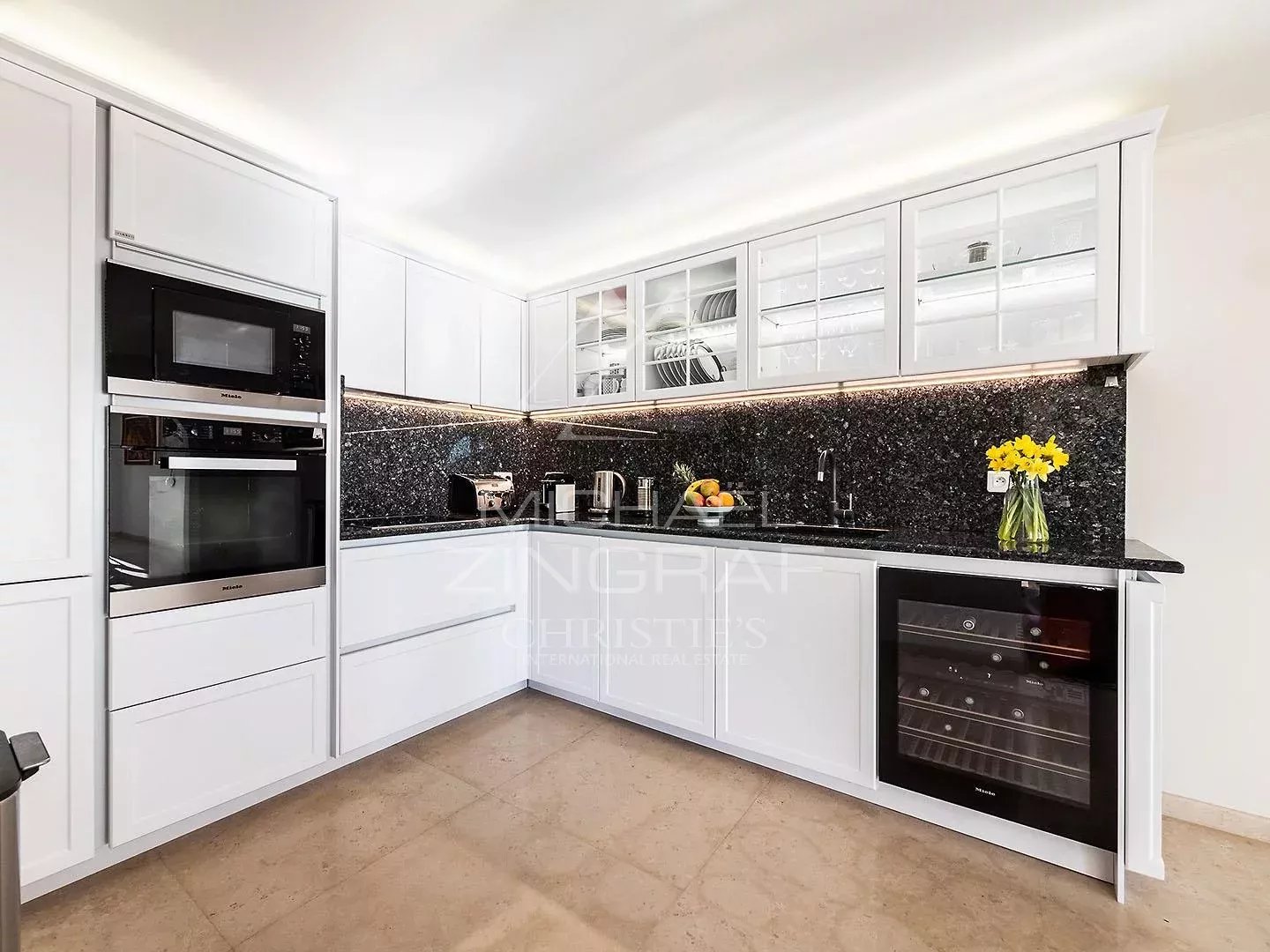Kitchen of a duplex in Villefranche-sur-Mer Modern kitchen with integrated appliances and a granite worktop.