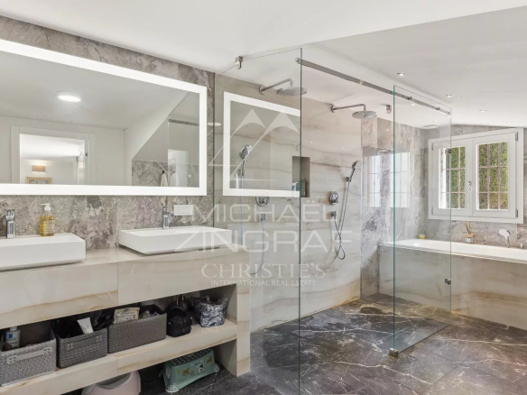 Modern bathroom with glass shower and bathtub in a duplex apartment in Villefranche-sur-Mer.