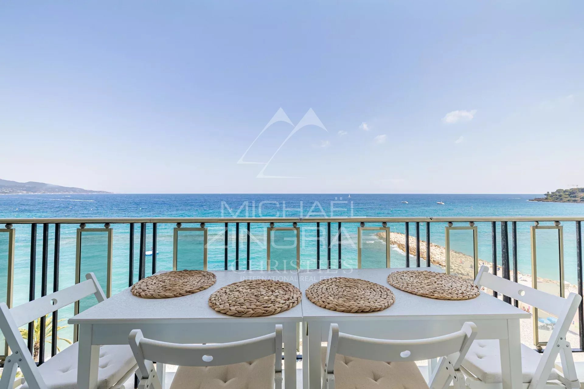 Penthouse avec vue mer à Roquebrune-Cap-Martin Terrasse d'un penthouse avec vue sur la mer à Roquebrune-Cap-Martin, table et chaises blanches.