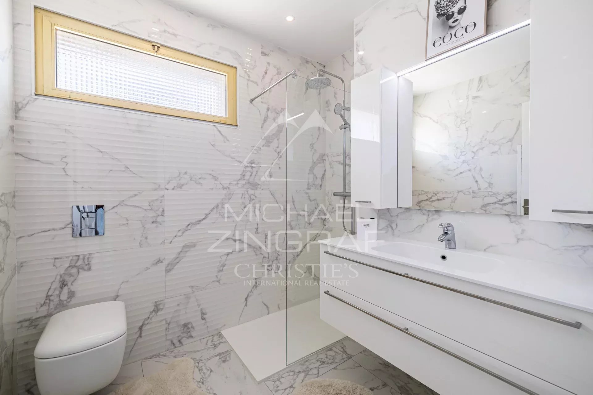 Salle de bain élégante Salle de bain moderne avec carrelage en marbre et mobilier blanc.