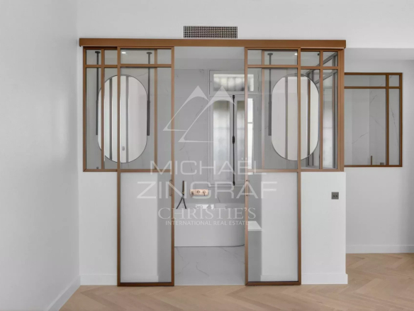 Intérieur d'un appartement rénové avec des cloisons en verre et bois, style moderne.