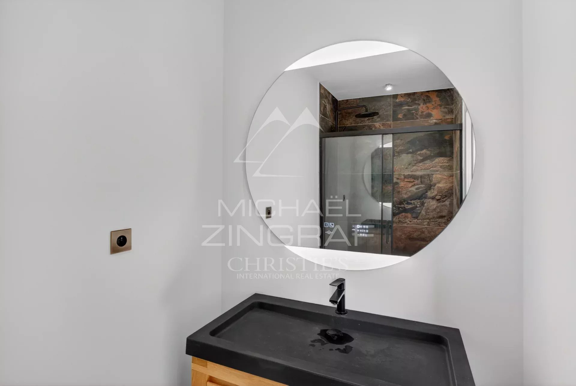 Salle de bain contemporaine Salle de bain moderne avec miroir rond et lavabo en pierre.