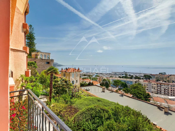Vue panoramique sur la mer depuis un appartement à Beaulieu-sur-Mer, avec jardins et bâtiments environnants.