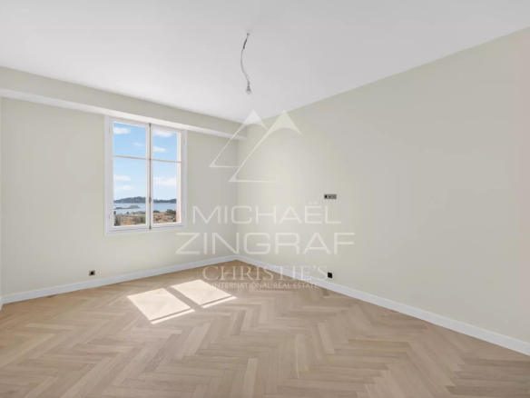 Intérieur d'un appartement rénové à Beaulieu-sur-Mer avec parquet et vue sur la mer.