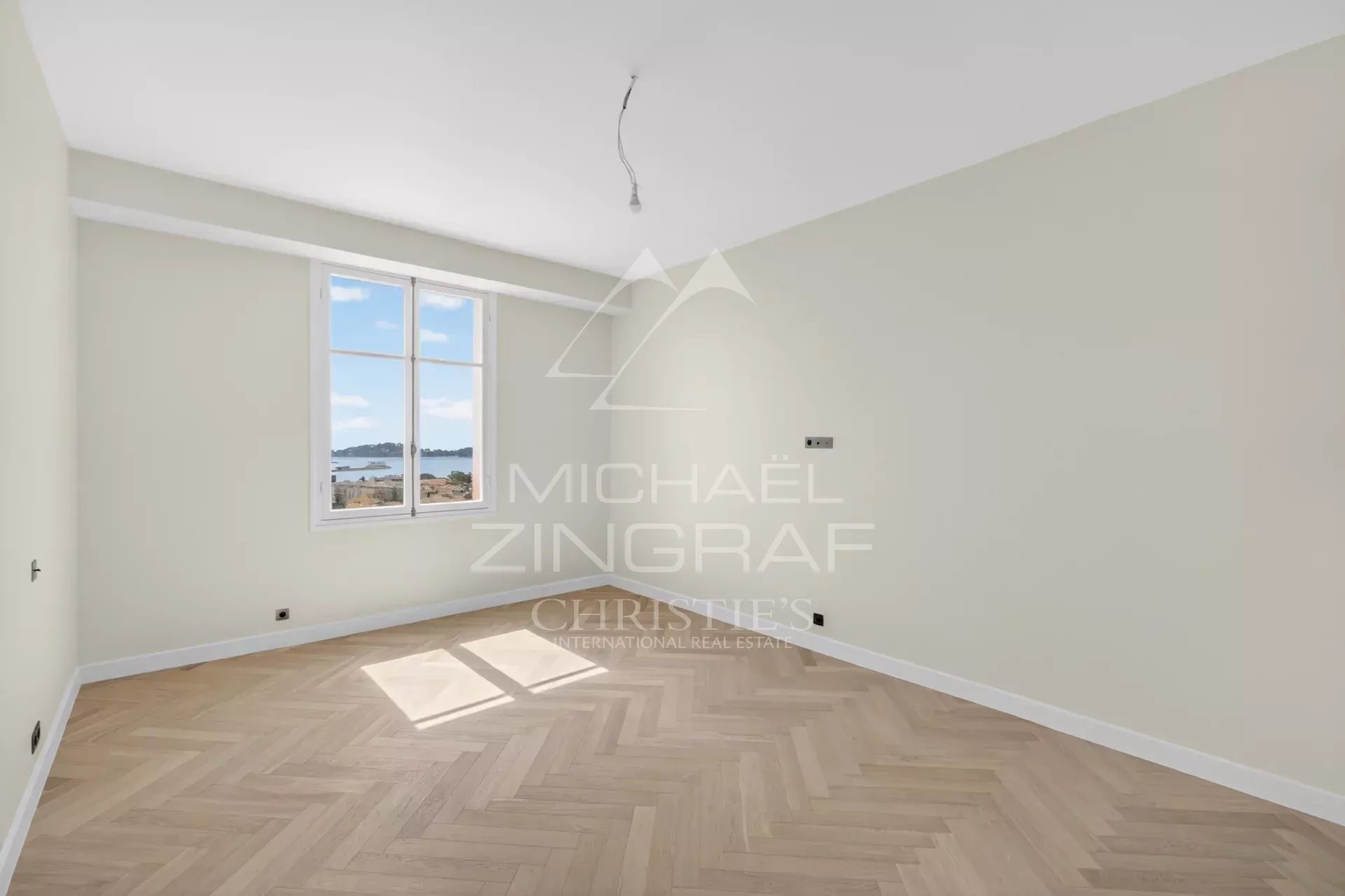 Appartement d’exception à Beaulieu-sur-Mer Intérieur d'un appartement rénové à Beaulieu-sur-Mer avec parquet et vue sur la mer.