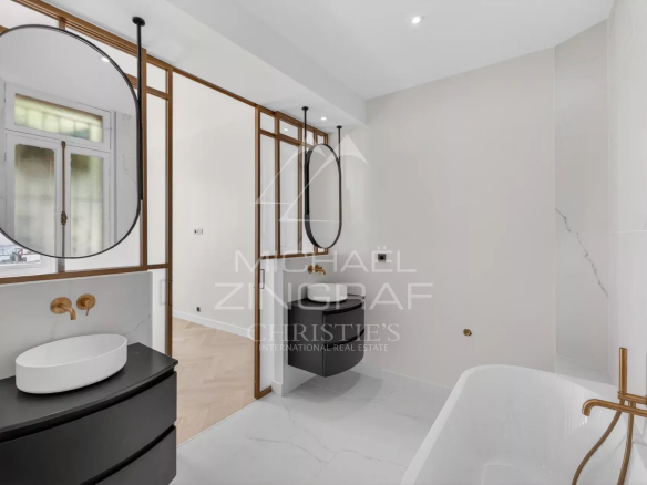 Salle de bain moderne avec baignoire, lavabos et miroirs élégants.