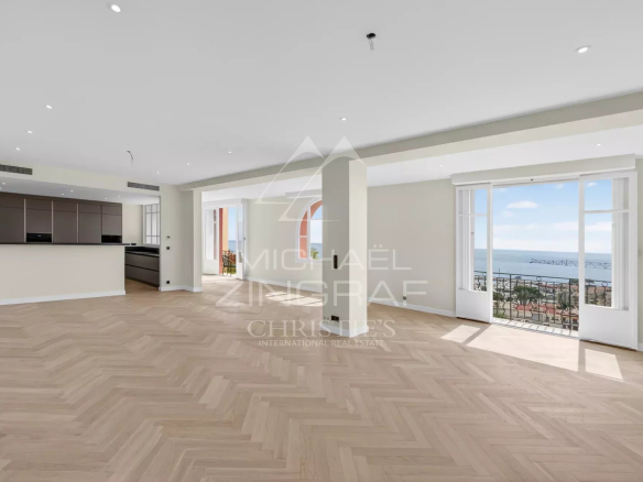 Intérieur d'un appartement rénové à Beaulieu-sur-Mer avec vue sur la mer et grandes baies vitrées.