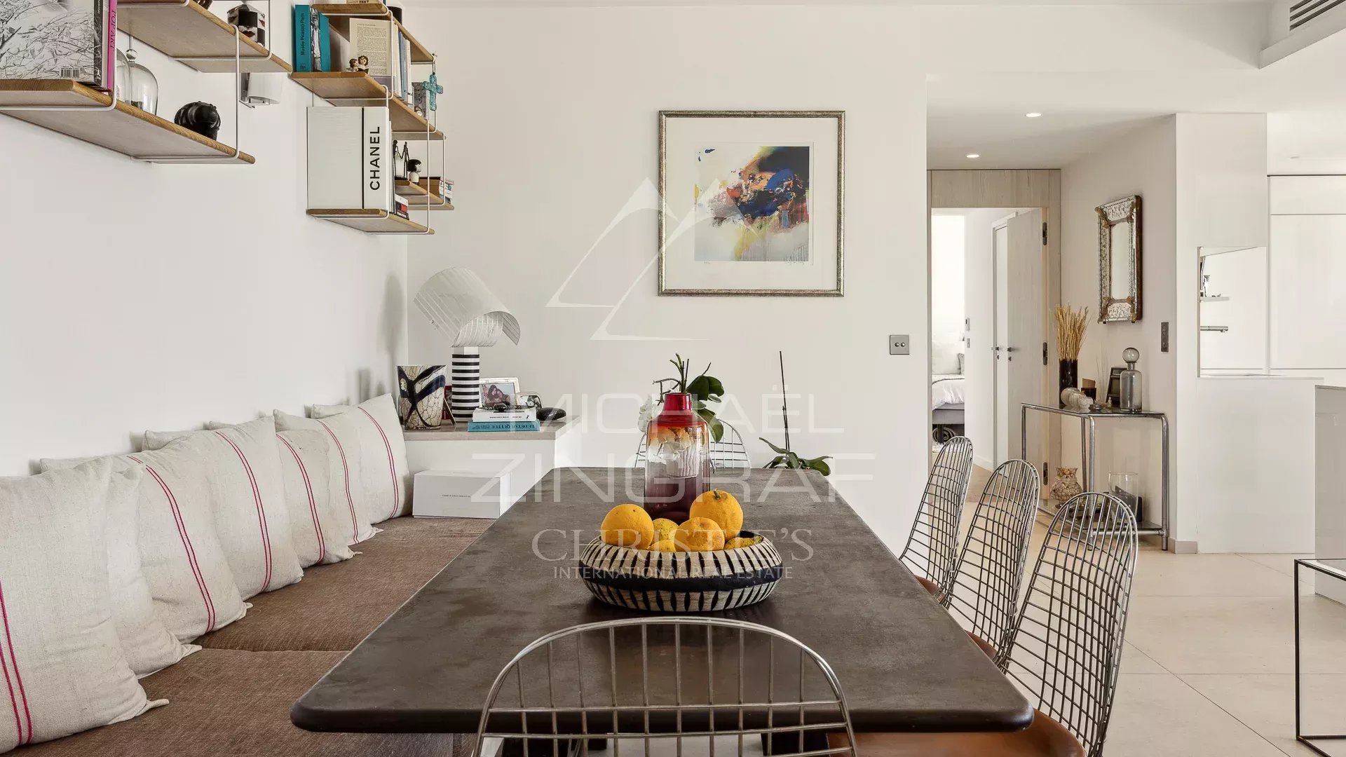 Appartement moderne à Èze Intérieur d'un appartement moderne à Èze avec une grande table à manger et des coussins décoratifs.