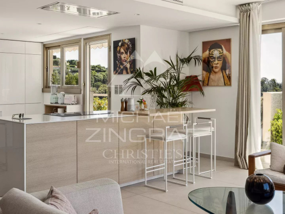 Intérieur d'un appartement moderne avec cuisine ouverte et grande fenêtre, vue sur la terrasse.