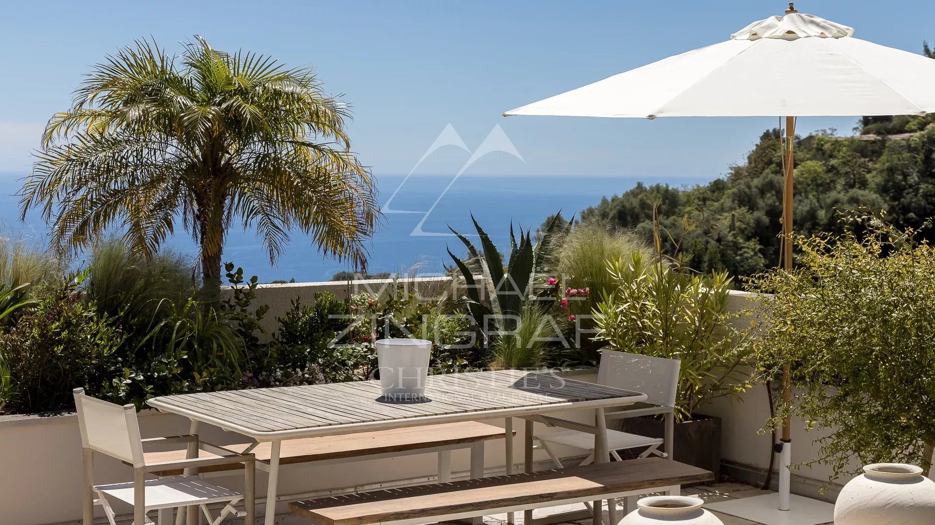 Terrasse avec vue à Èze Terrasse d'un appartement à Èze avec vue sur la mer Méditerranée et des plantes.