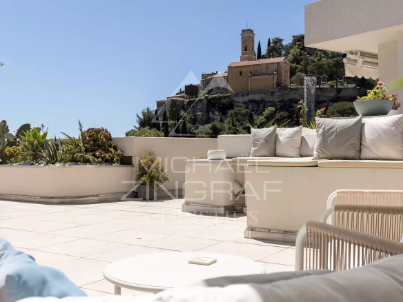 Terrasse d'un appartement à Èze avec vue sur le village et la mer Méditerranée.