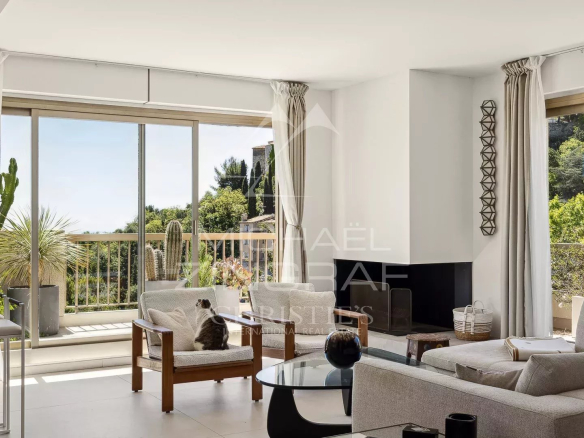 Intérieur d'un appartement moderne à Èze avec salon lumineux et accès à une terrasse.