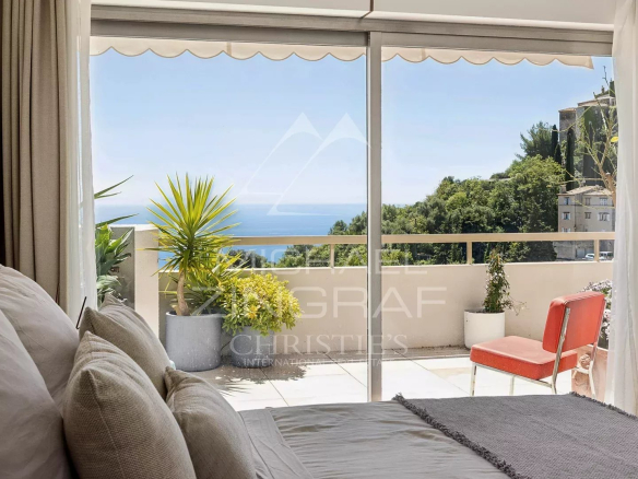 Intérieur d'un appartement à Èze avec vue sur la mer et une terrasse ensoleillée.