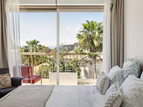 Chambre d'un appartement à Èze avec vue sur la mer et des palmiers à l'extérieur.